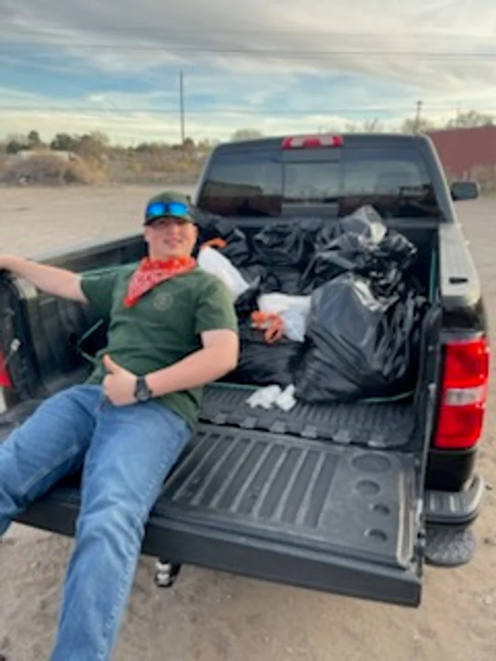 Cruces Scoopers crew member with collected waste loaded for removal